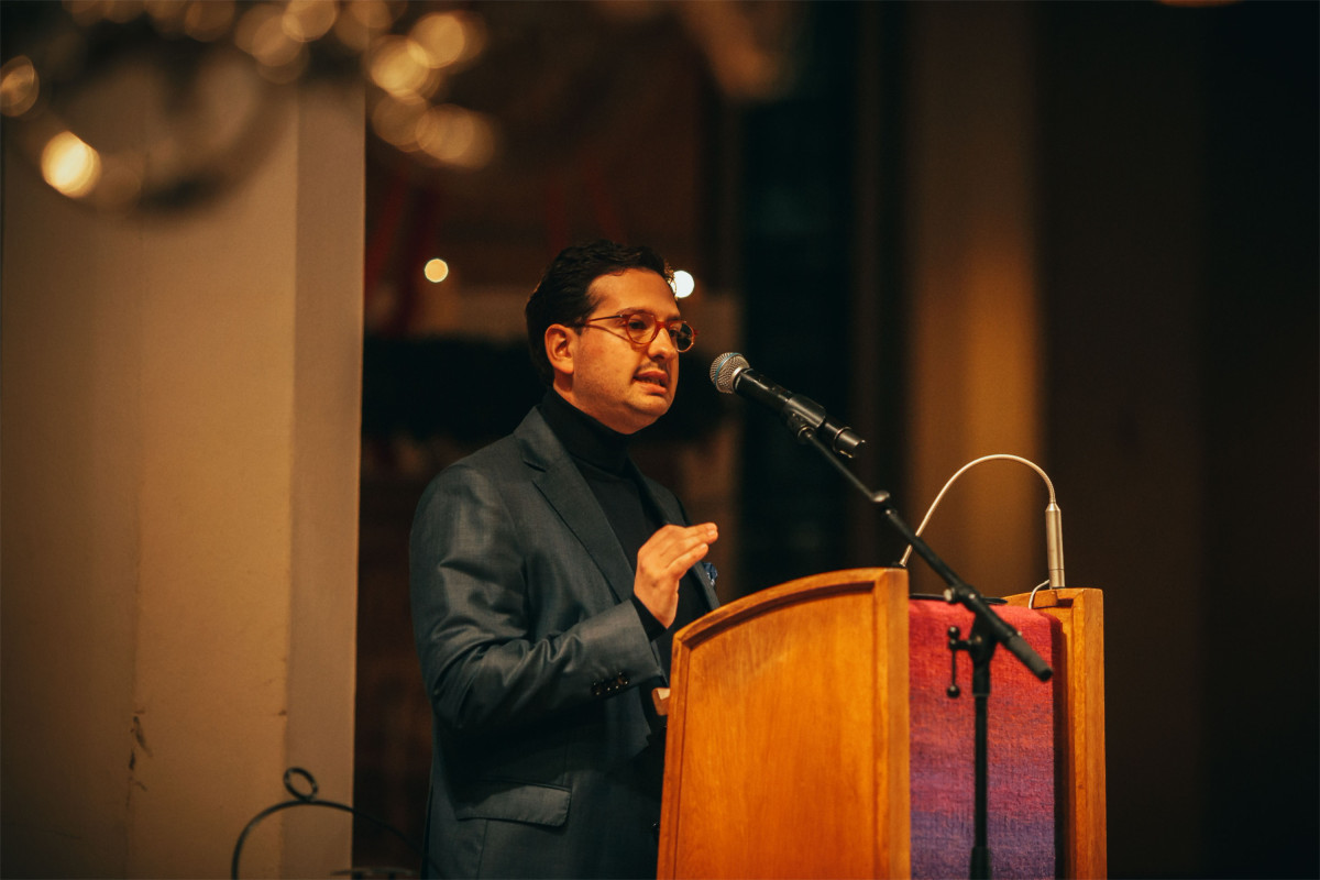 Bastian Mahmoodi spricht bei einer Abendveranstaltung am Rednerpult in einem festlich beleuchteten Saal.