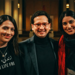 Bastian Mahmoodi steht mit zwei Frauen in einer Kirche und blickt in die Kamera.