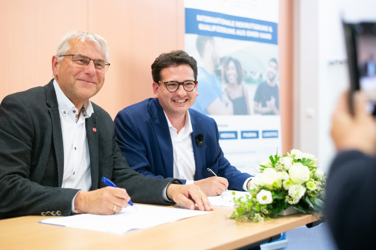 Bastian Mahmoodi und ein Vertreter der Westküstenkliniken unterzeichnen eine Kooperationsvereinbarung.